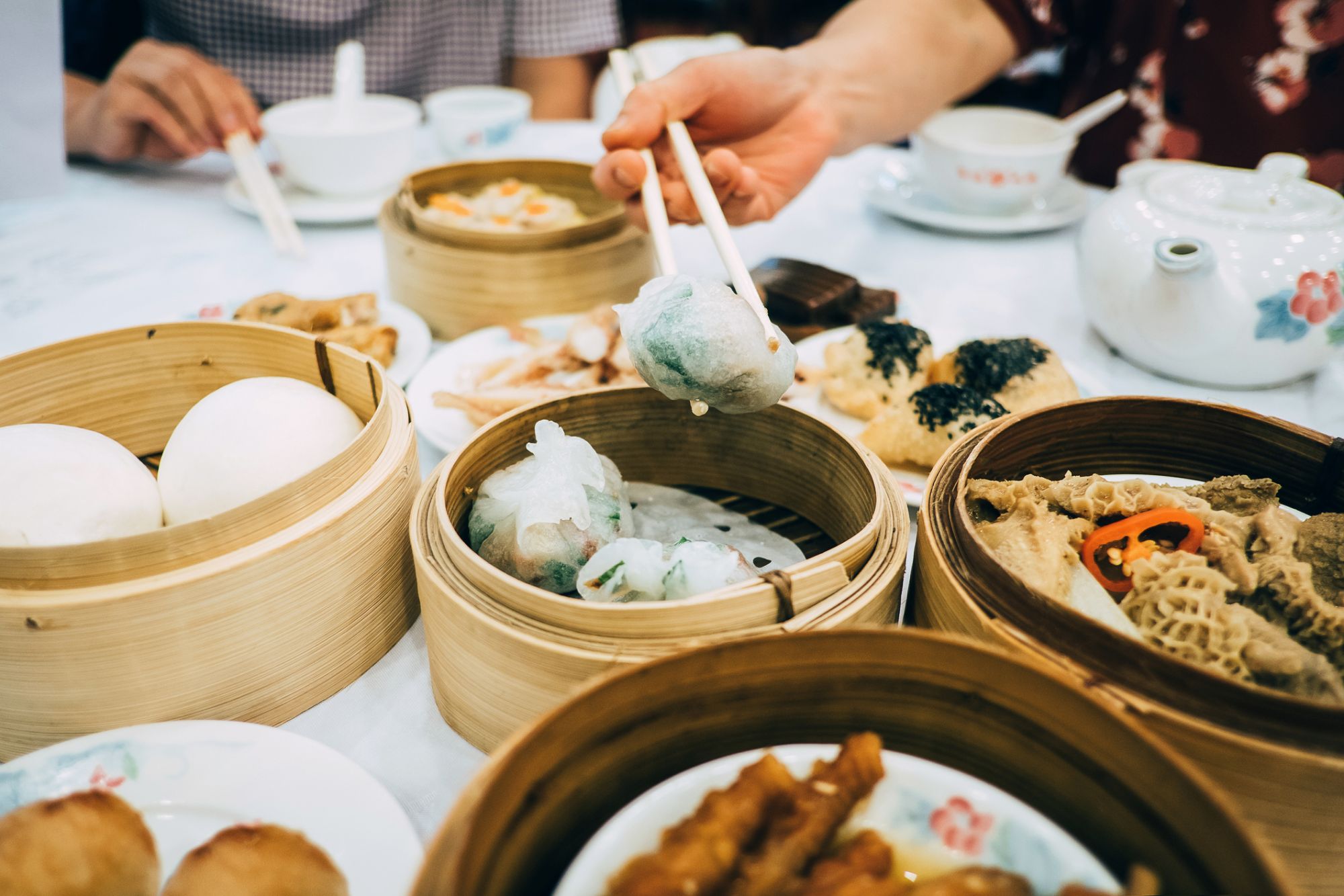 Family enjoying family time and having a variety of traditional dim sum in Chinese restaurant