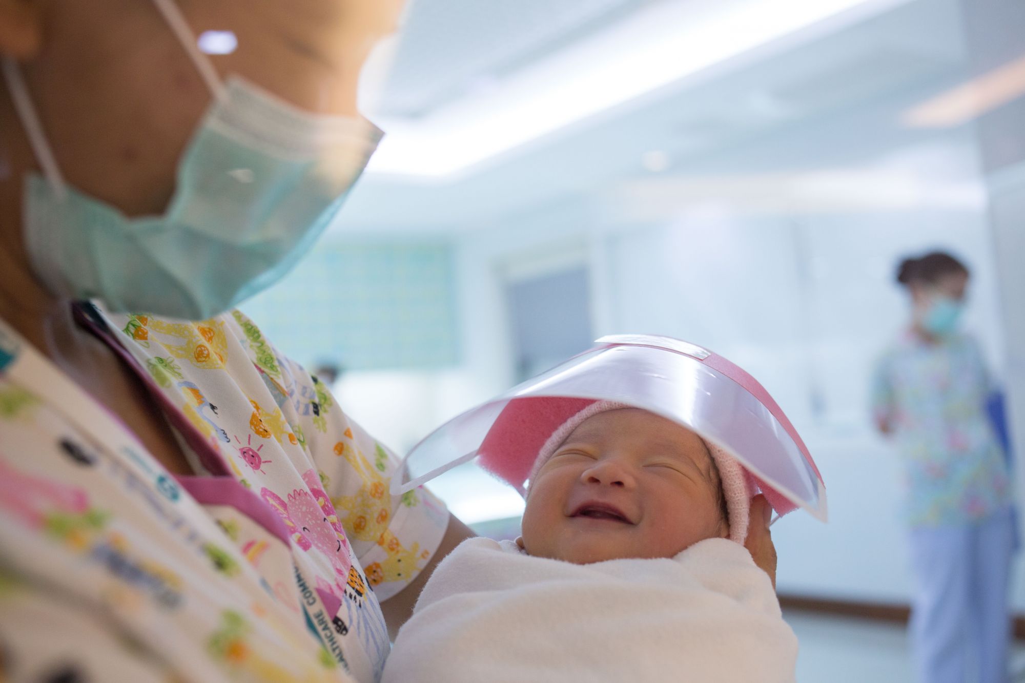 BANGKOK, THAILAND - APRIL 13: A nurse seen holding a new born baby smiling under a tiny face shield against the coronavirus (COVID-19) pandemic at Praram 9 Hospital on April 13, 2020 in Bangkok, Thailand. Thailand's Health Ministry recorded a total of 2,579 infections, 40 death and 1,288 recovered since the beginning of the outbreak. (Photo by Guillaume Payen/Anadolu Agency via Getty Images)