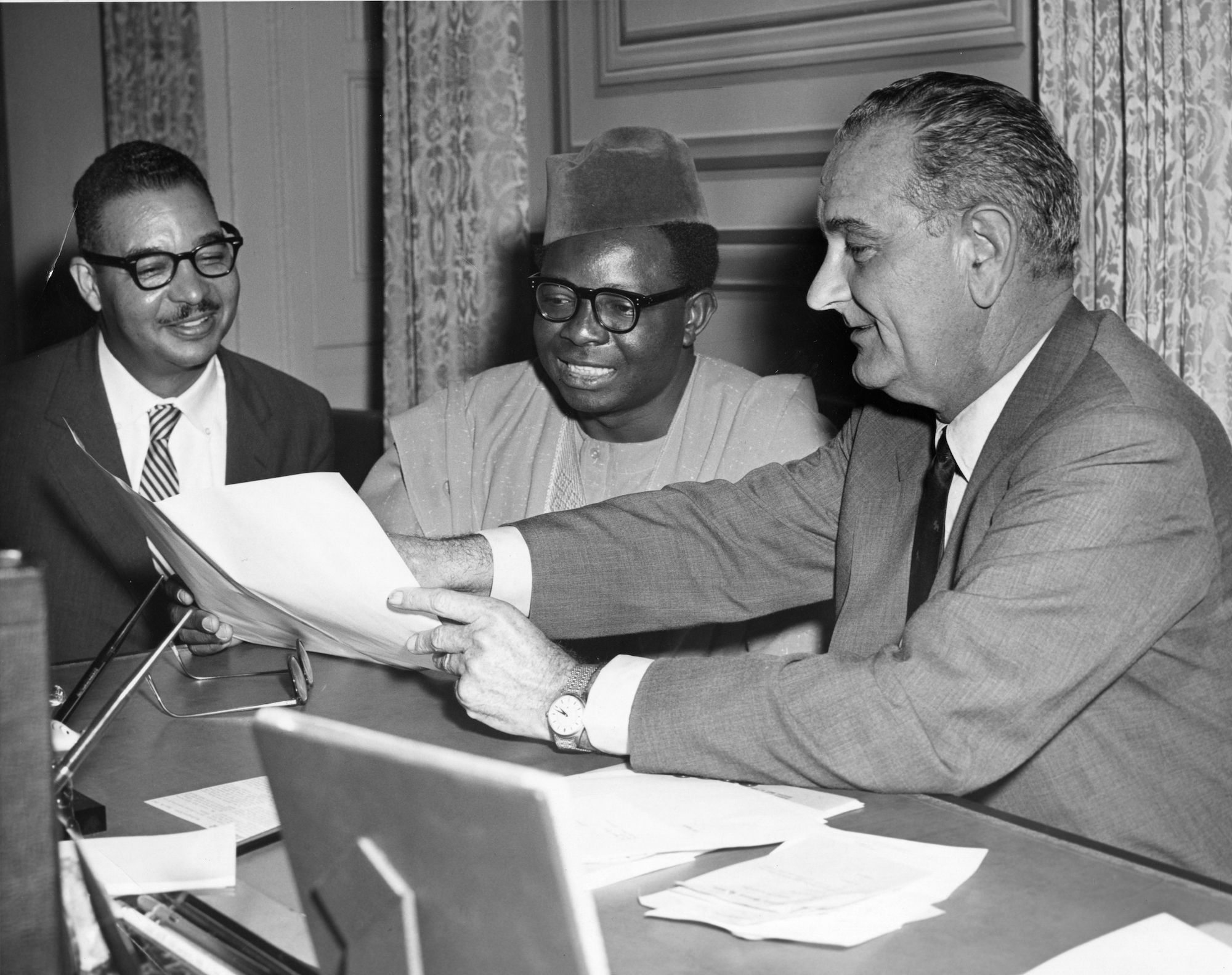 US President Lyndon Baines Johnson (1908 - 1973) (left) shows a document to Somalia Prime Minister Muhammad Ibrahim Egal (1928 - 2002) (center) as American journalist Louis E. Martin (1912 - 1997) watches, Washington DC, March 14, 1968. (Photo by The Abbott Sengstacke Family Papers/Robert Abbott Sengstacke/Getty Images)