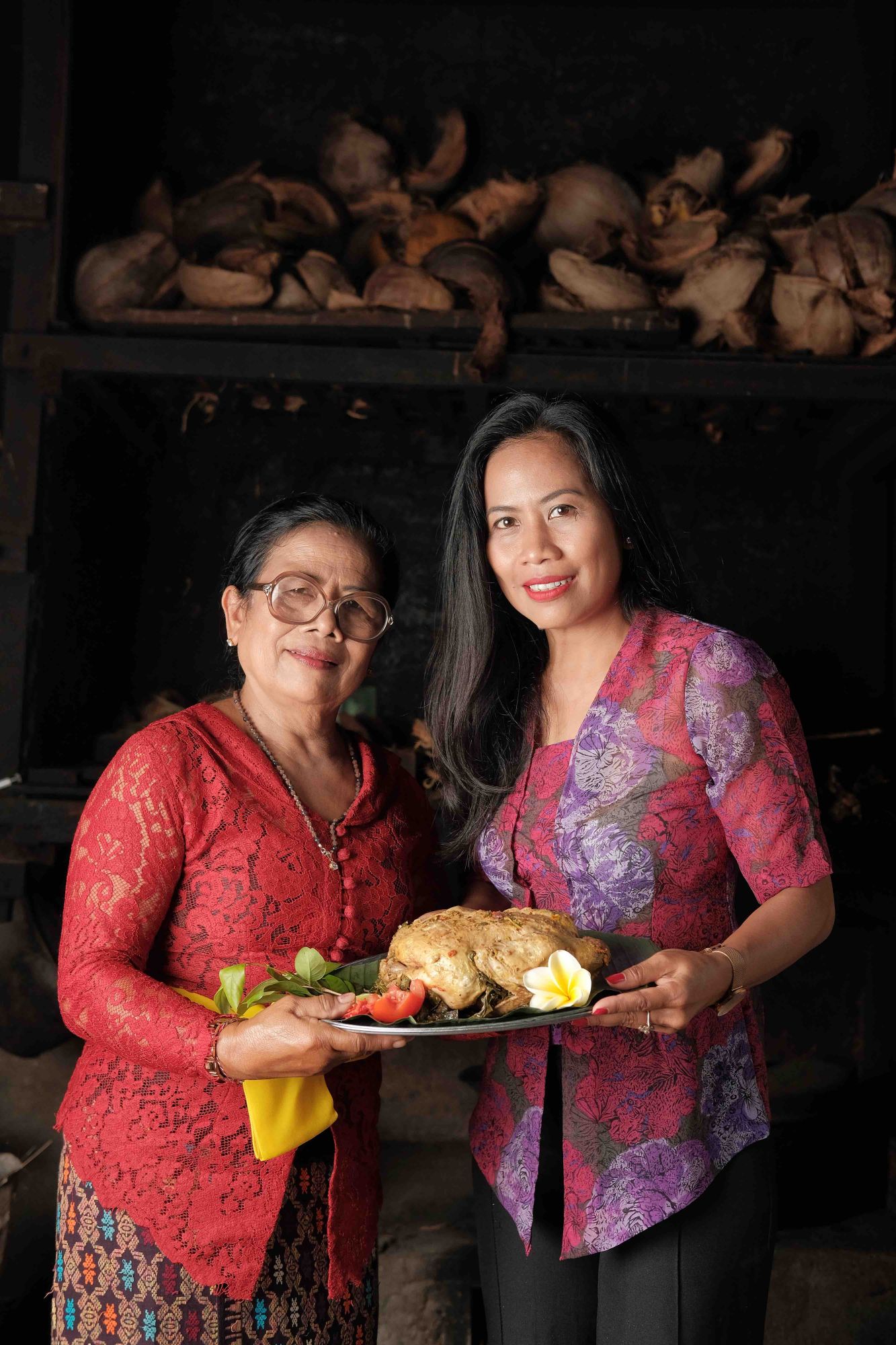 Ginger Moon Canteen's restaurant manager Ayu, with her mother holding Ayam Betutu, the recipe for which is included in Our Bali Your Bali