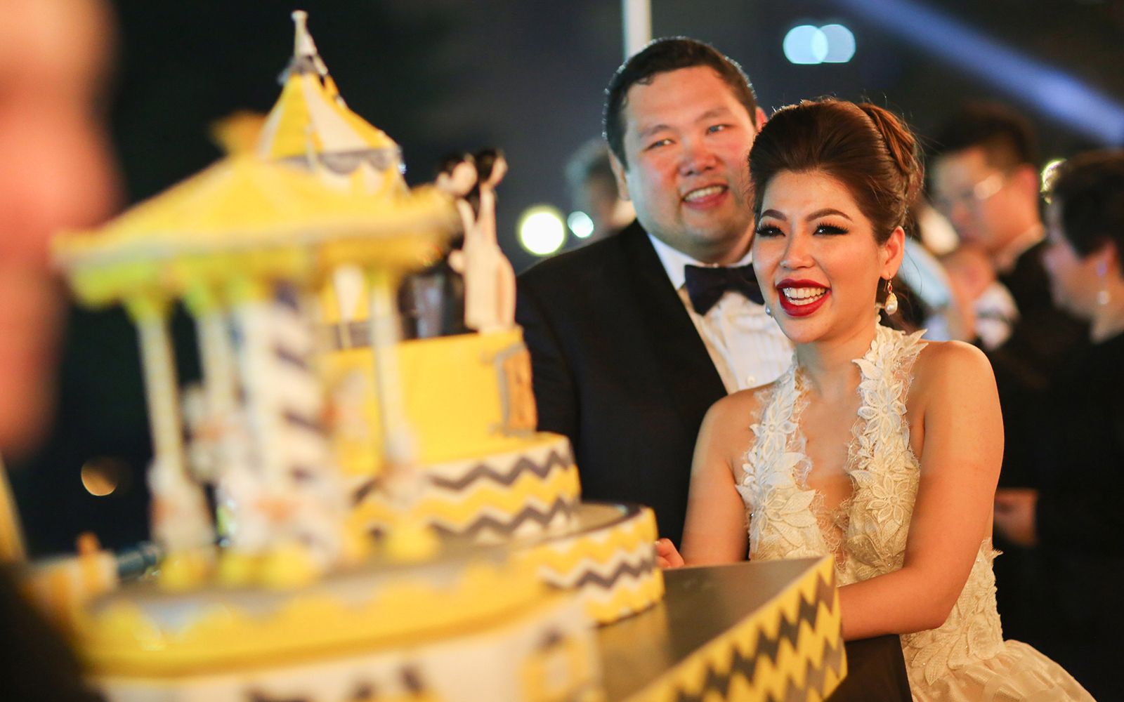 Ben and Liz, all smiles at their carnival-themed wedding in Chin Woo Stadium, October 2014