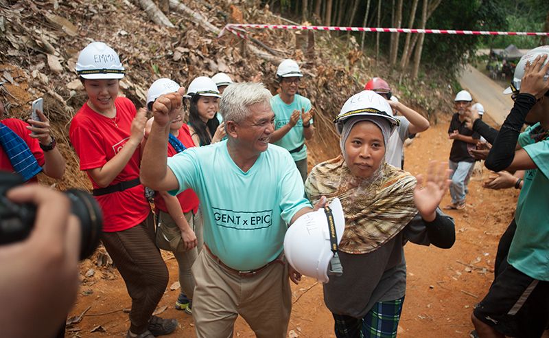 Abang Din and Kak Senum getting the celebrity treatment as they walk towards their newly built home.