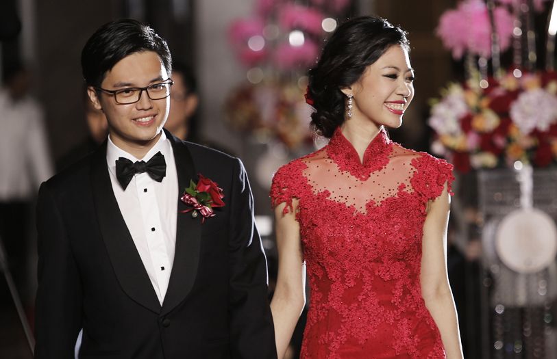 Justin Law and Kathleen Wong walking down the aisle at their wedding reception