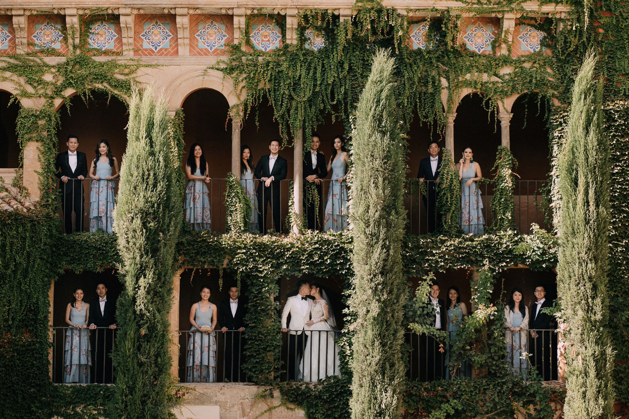 The couple and their bridal entourage pose in a pretty spot of the castle where the wedding took place