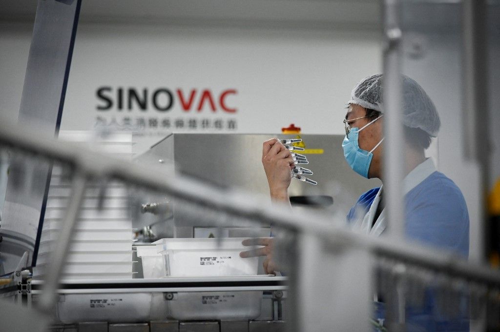 A staff member works during a media tour of a new factory built to produce a COVID-19 coronavirus vaccine at Sinovac, one of 11 Chinese companies approved to carry out clinical trials of potential coronavirus vaccines, in Beijing on September 24, 2020. (Photo by WANG ZHAO / AFP)