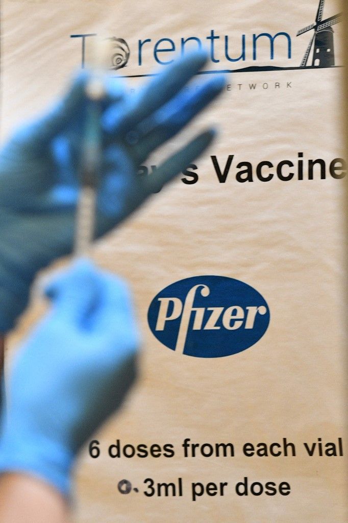 A poster reminds healthcare professionals that the vaccine they are using is the Pfizer/BioNTech Covid-19 vaccine and that they should draw six doses of 0.3ml from each vial at a vaccination centre set up at Thornton Little Theatre managed by Wyre Council in Thornton-Cleveleys, northwest England, on January 29, 2021 as Britain's coronavirus vaccination campaign continues. - The US pharmaceutical giant Pfizer, which is manufacturing the Covid-19 vaccine developed by Germany's BioNTech, now considers each via