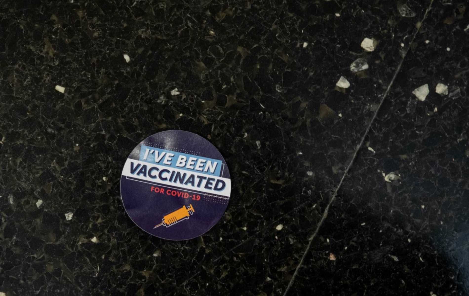 A sticker that reads ÂIÂve been vaccinated for Covid-19Â is seen on the floor in a hallway at Thomas Jefferson University Hospital in Philadelphia, Pennsylvania on December 16, 2020. - Today was the first day PfizerÂs Covid-19 vaccine was administered for the staff of Jefferson Health in Philadelphia. The vaccine is voluntary and is available to staff via invitation, with those who have the most exposure to Covid-19 patients given first priority for inoculation. (Photo by GABRIELLA AUDI / AFP)