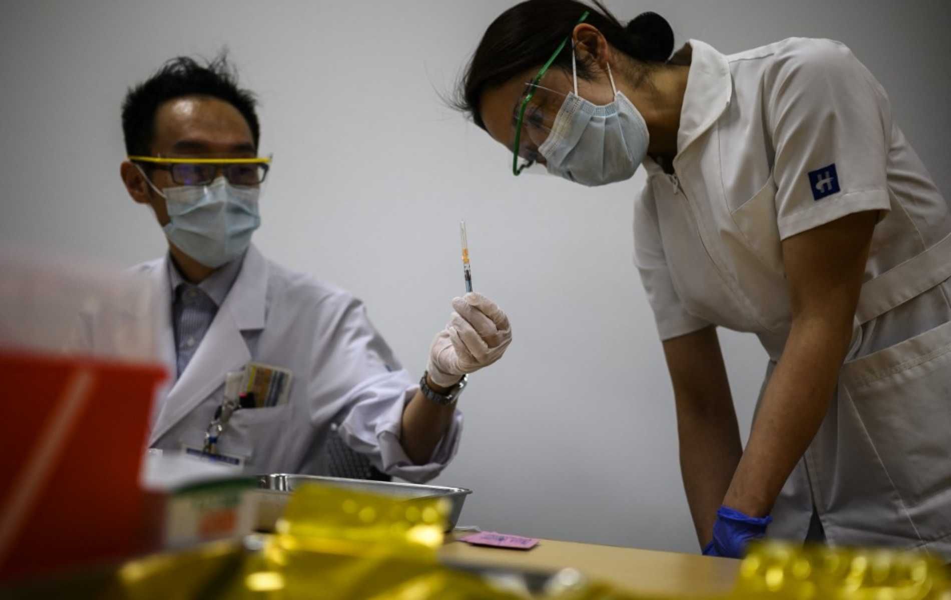 A nurse makes an inspection after a medical worker filled a syringe with a dose of the Pfizer-BioNTech Covid-19 vaccine as Japan launches its inoculation campaign at the Tokyo National Hospital in Kiyose, Tokyo prefecture on February 17, 2021. (Photo by CHARLY TRIBALLEAU / AFP)
