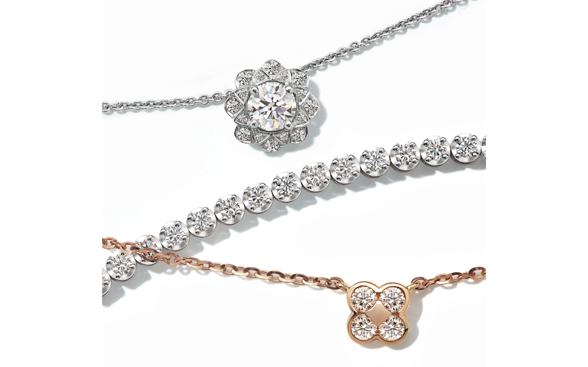 The Love Diamond blossom-set tennis bracelet sits amongst two everyday diamond floral motif pendants