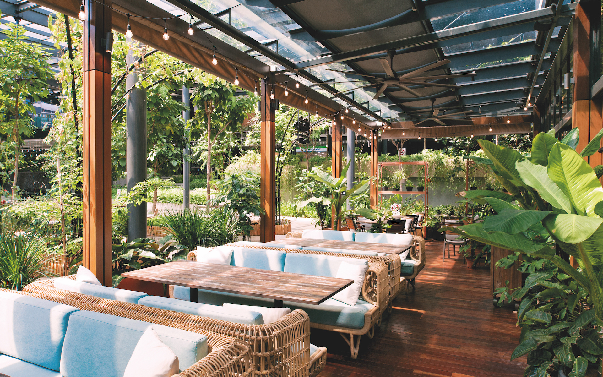 The pleasant outdoor terrace has filtered natural light and comfortable cane sofas
