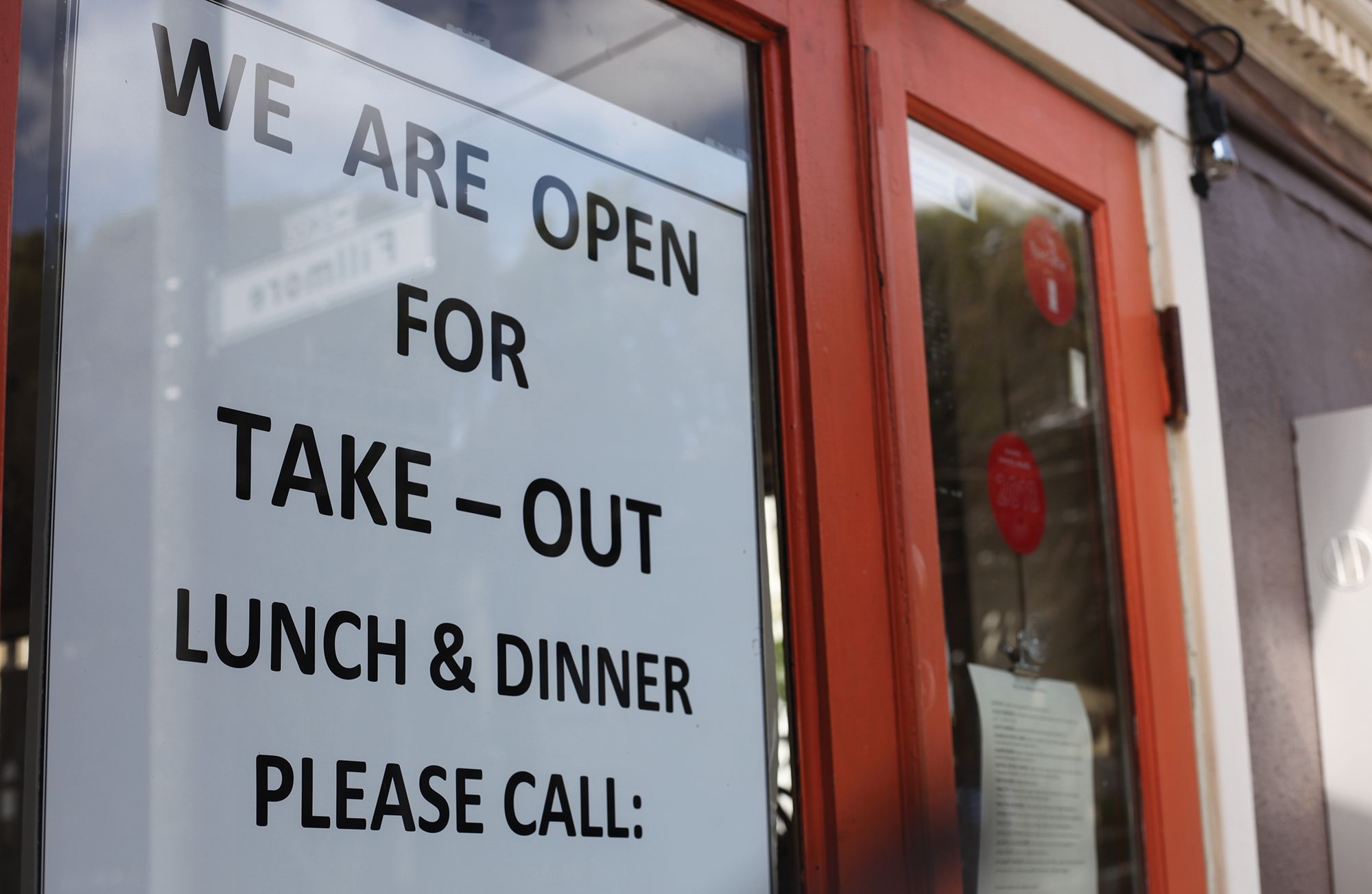 "We are open for take-out Lunch & Dinner Please Call:" Sign on a restaurant window in San Francisco during the Coronavirus / COVID-19 Shelter in Place order.