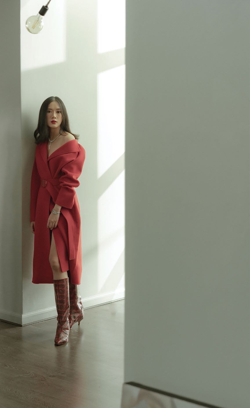 She wears a Serpenti Viper one-coil bracelet, Serpenti necklace, Serpenti Viper wedding band, all by Bvlgari, Louis Vuitton coat and Tibi boots.