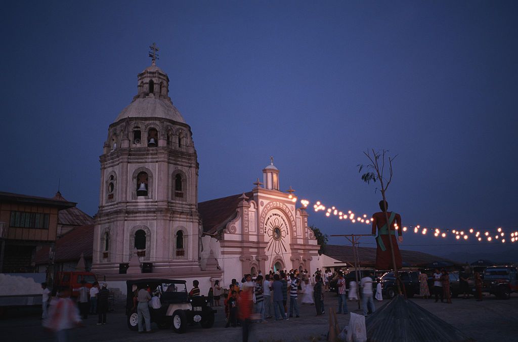 PAMPANGA, PHILIPPINES - 1997/04/01: The cathedral in Bacolor in the early morning on Easter Sunday. Visitors have to enter through the window since the entire building is partially covered in five meters of ash. Most houses here were washed away by lahars, (ash mixed with rain water) in the early morning of June 1st 1995. Over 20 villagers were killed in the disaster. The city of Bacolor used to have 65,000 inhabitants. Today just a few thousand are left. Hundreds of lahars, triggered by heavy rain, formed