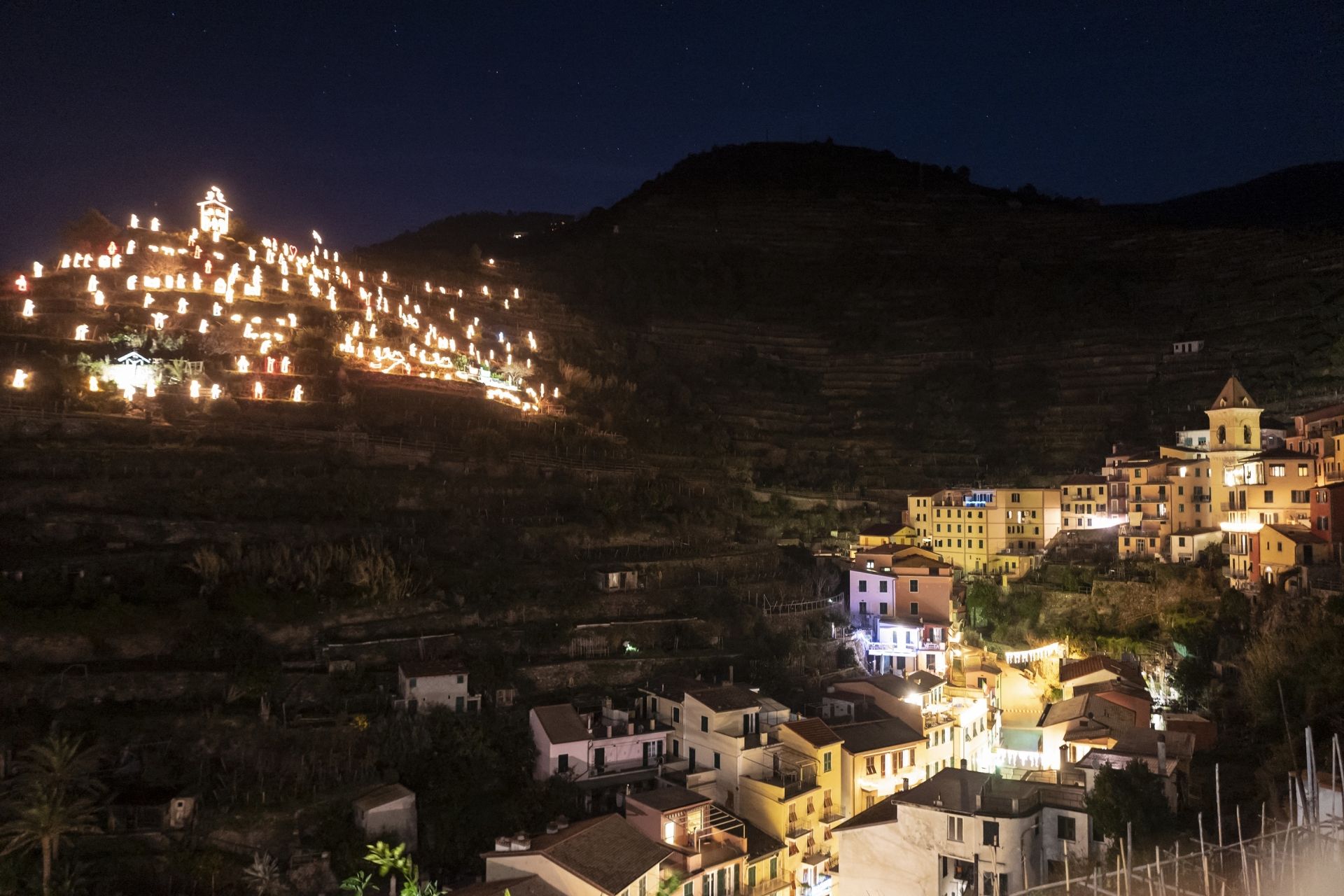 The Manarola Nativity Scene shines from a hill next to Manarola, Cinque Terre, Northwestern Italy, on December 14, 2020. - The Nativity scene is made by more than 150 statues illuminated by 8 km of electricity cables. (Photo by Marco Bertorello / AFP)
