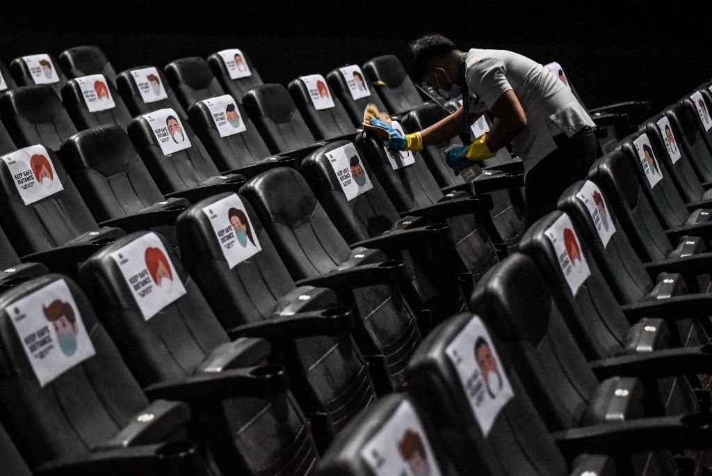 A man disinfects the chairs at SM Cinema in Santa Rosa, Laguna in the Philippines on October 18, 2020.(Photo by Lisa Marie David/NurPhoto via Getty Images)