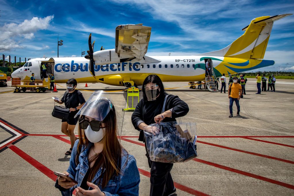 MALAY, PHILIPPINES - SEPTEMBER 30: Travelers wearing face masks and face shields to protect against COVID-19 disembark a plane at Godofredo P. Ramos Airport on September 30, 2020 in Malay, Aklan province, Philippines. The Philippine government has partially reopened the country to domestic travelers in a bid to stimulate the economy and revive a pandemic-hit tourism sector even as coronavirus cases continue to rise. The country surpassed 312,000 cases of COVID-19, with at least 5,504 deaths. (Photo by Ezra