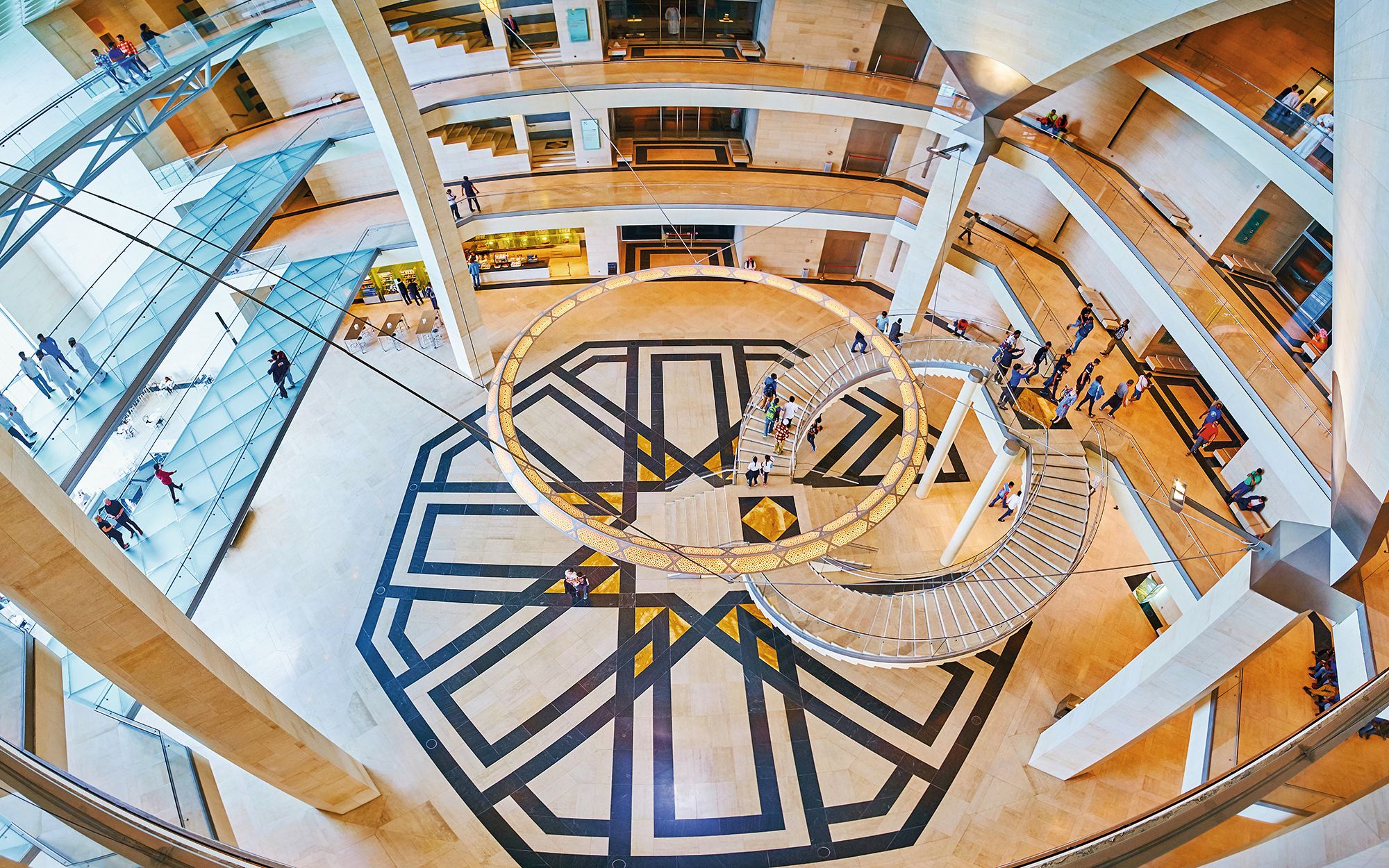 DOHA, QATAR - FEBRUARY 13, 2018: Explore interesting architecture of Islamic Art Museum with large hall, decorated with Islamic geometric patterns, curved staircase and huge chandelier, on February 13 in Doha.