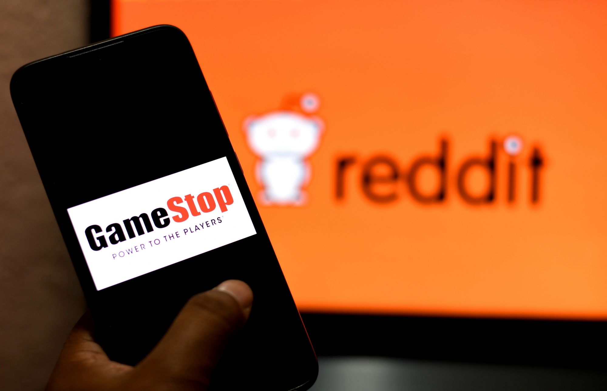 INDIA - 2021/02/04: In this photo illustration a Gamestop logo seen displayed on a smartphone and a Reddit logo in the background. (Photo Illustration by Avishek Das/SOPA Images/LightRocket via Getty Images)