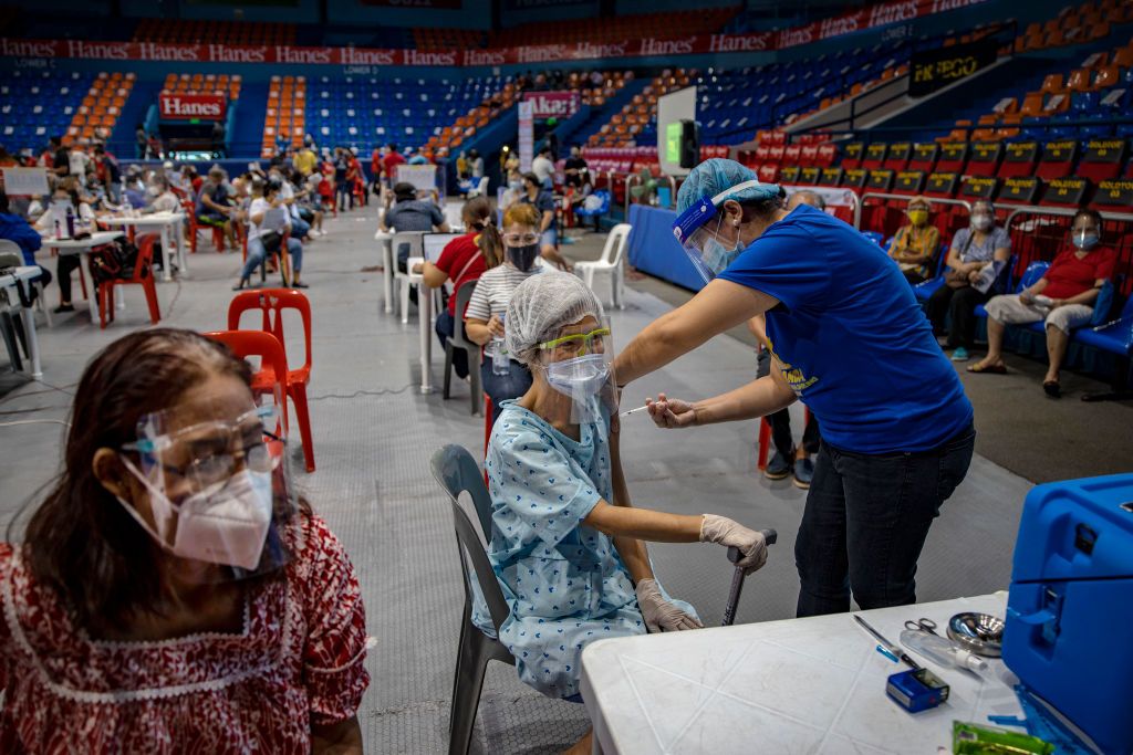 MANILA, PHILIPPINES - MARCH 30: An elderly woman is administered with the AstraZeneca COVID-19 vaccine at a sports arena on March 30, 2021 in San Juan, Metro Manila, Philippines. The Philippine government has once again put some 24 million people in Manila and nearby provinces under a strict quarantine as cases of the coronavirus hit daily records. The Philippines has confirmed more than 741,000 cases of COVID-19 so far, with more than 124,000 active cases. (Photo by Ezra Acayan/Getty Images)