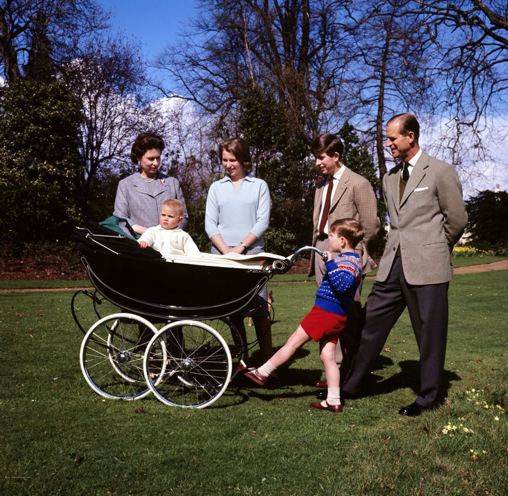 Prince Andrew, who is at the handle of the pram, rocks Prince Edward, watched by (l-r) his mother, Queen Elizabeth II, Princess Anne, the Prince of Wales, and his father, the Duke of Edinburgh. (Photo by PA Images via Getty Images)