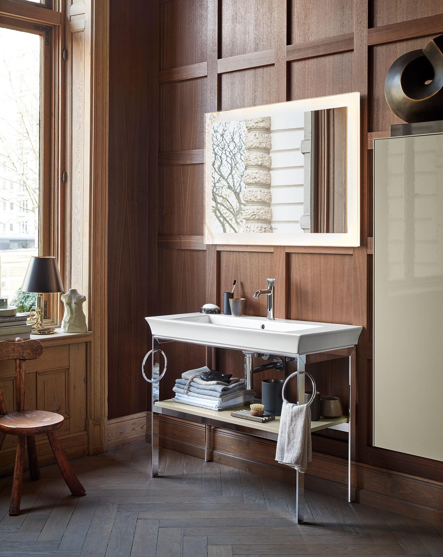 The floor-standing chrome console with wooden shelves is an especially stylish feature. It can also be fitted with one or two practical round towel holders. Matching White Tulip mirrors add the finishing touch to this sophisticated washing area.