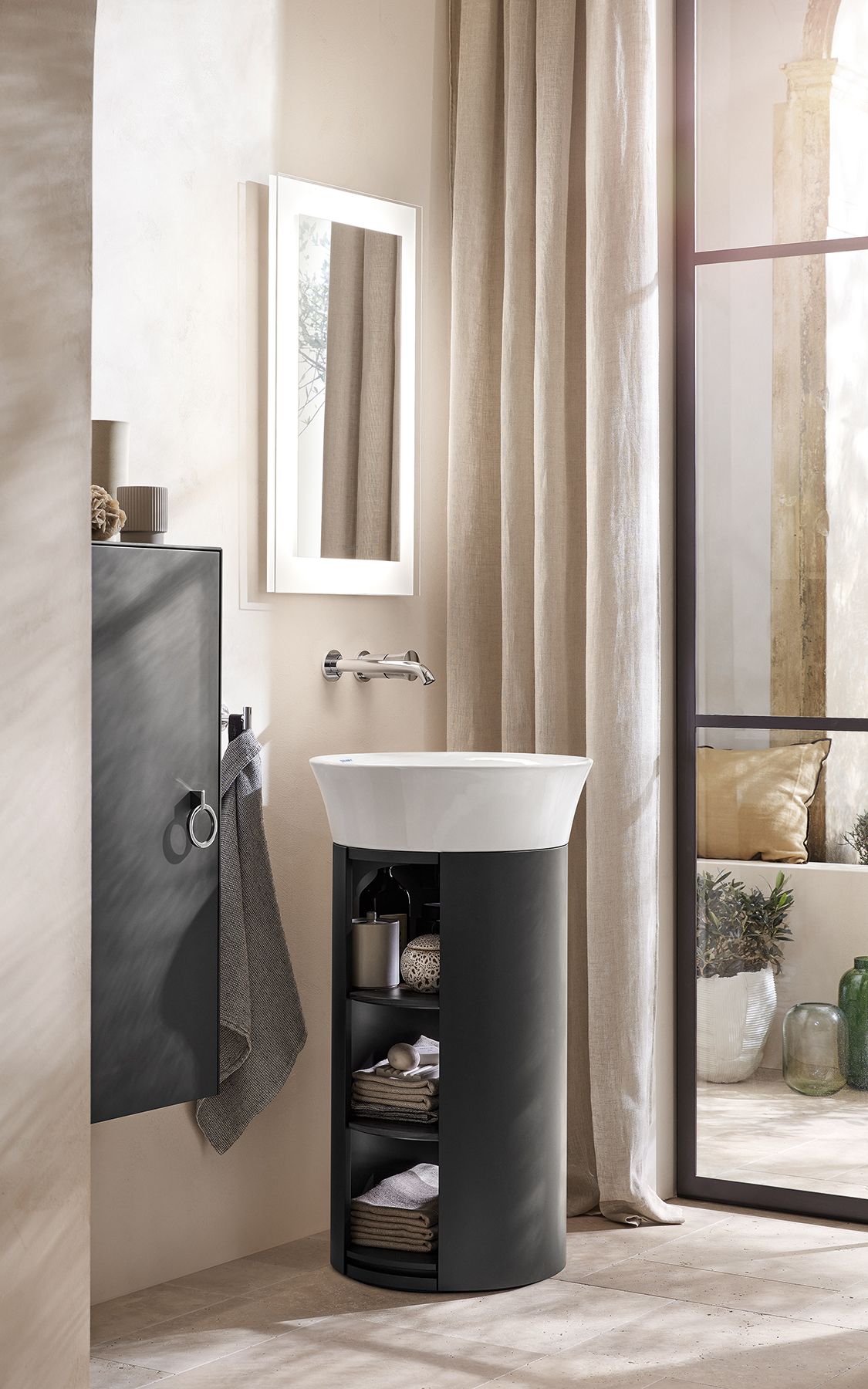 A further option providing practical storage space is a combination of the round furniture washbasin and the matching vanity unit with open-sided racks.