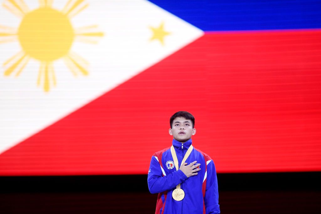 STUTTGART, GERMANY - OCTOBER 12: Gold medalist Carlos Edriel Yulo of Philippines participates in the Philippine national anthem during the medal ceremony for Men's Floor Exercise Final in the Apparatus Finals during Day 9 of 49th FIG Artistic Gymnastics World Championships at Hanns-Martin-Schleyer-Halle on October 12, 2019 in Stuttgart, Germany. (Photo by Laurence Griffiths/Getty Images)