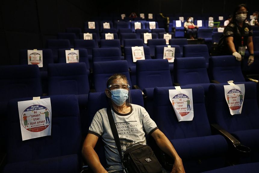 A Filipino resting inside a cinema after being inoculated with the Sinovac Covid-19 vaccine in San Juan City, Metro Manila. Malls that have been providing space for the vaccine roll-out have been offering banana fritters and free parking. Some restaurants, including McDonald's, are offering discounts to those with proof of vaccination. | Photo: EPA-EFE
