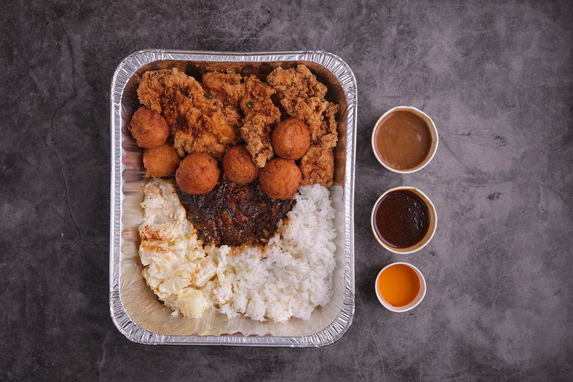 Chow down on Fireside’s buttermilk fried chicken fingers and apricot chipotle glazed ribs with cornbread doughnuts, steamed rice, and potato salad by ordering take home tray one.