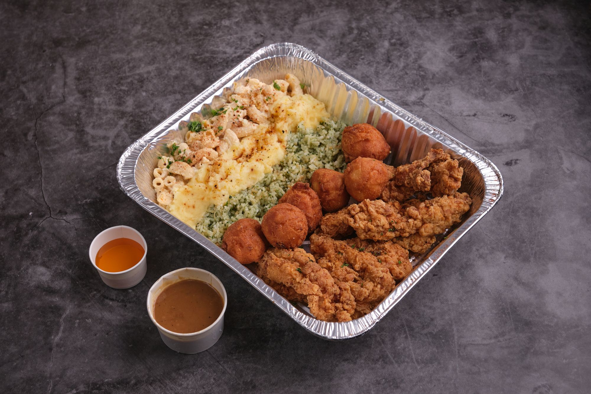 Take home tray three is perfect for those who love their sides.- it includes macaroni salad, cornbread doughnuts, garlic mashed potato, and rice alongside their fried chicken fingers.