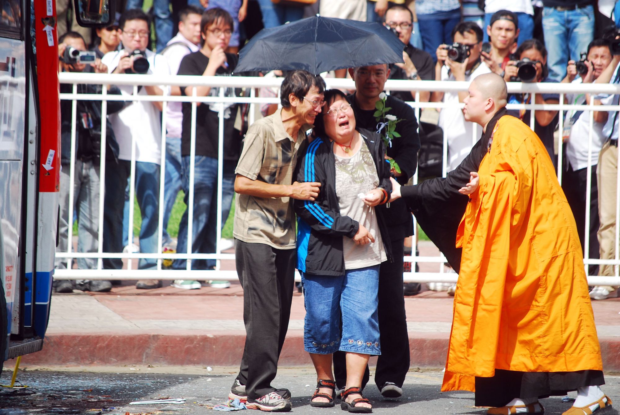 MANILA, PHILIPPINES - AUGUST 24: Family members of some of the victims weep and offer prayers during a Buddhist ceremony, after a hostage stand-off that resulted in the death of 8 hostages and the gunman, on August 24, 2010 in Manila, Philippines. The gunman, a 55 year old former police captain, high jacked the bus full of Chinese tourists dressed in combat gear and carrying an M16 rifle in a desperate act to get his job back. Manila police surrounded the bus after the gunman called a radio station and an