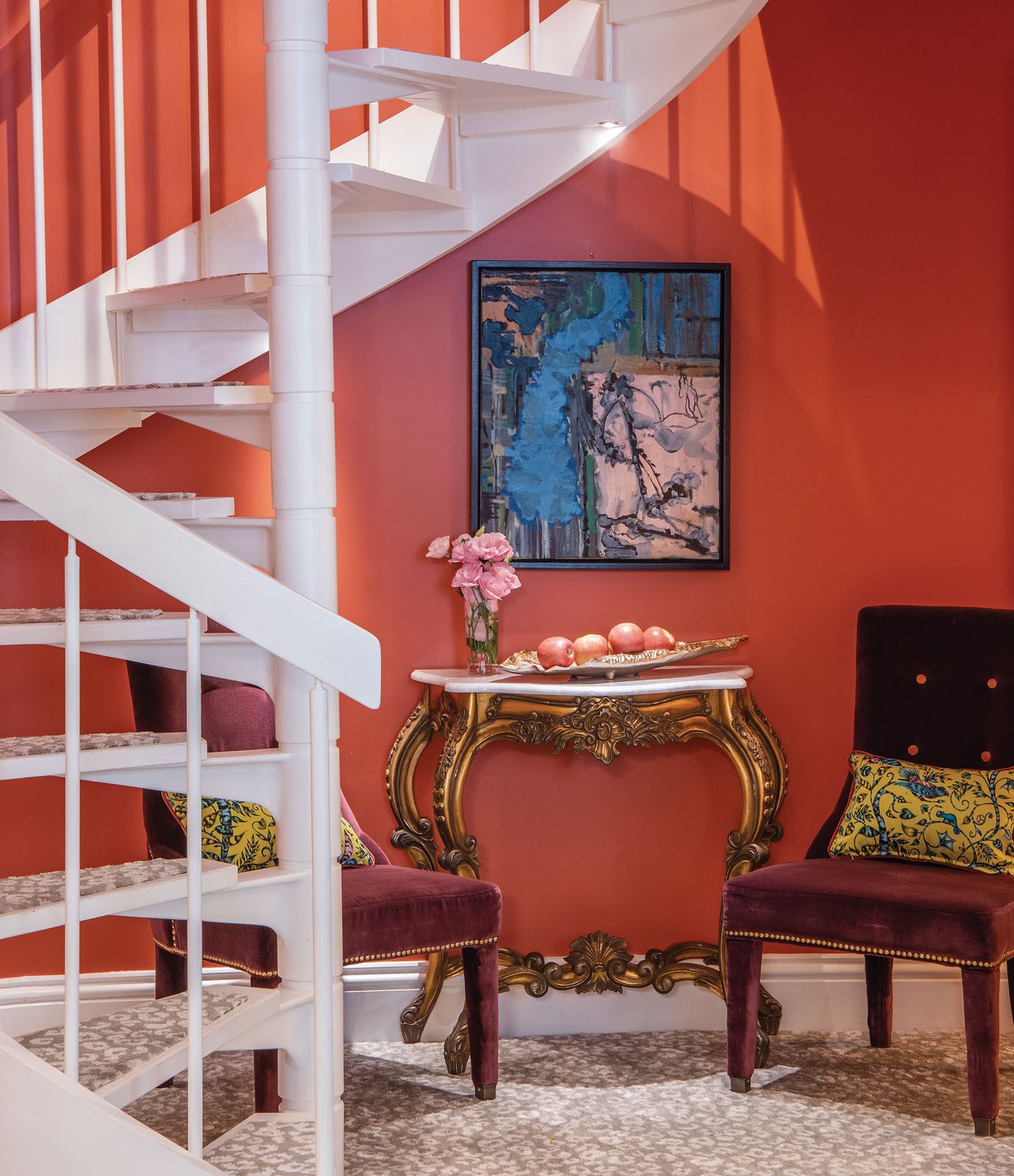 The bright orange wall paint enlivens a corner by the staircase