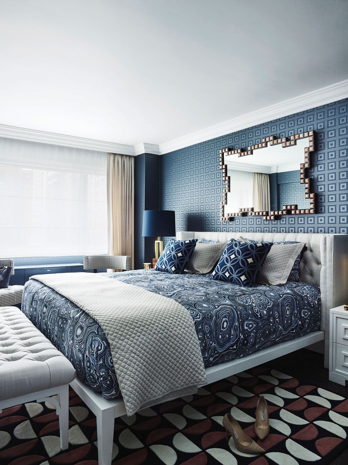 Maroon accents on the rug add a pleasing contrast to the serene blues in the master bedroom