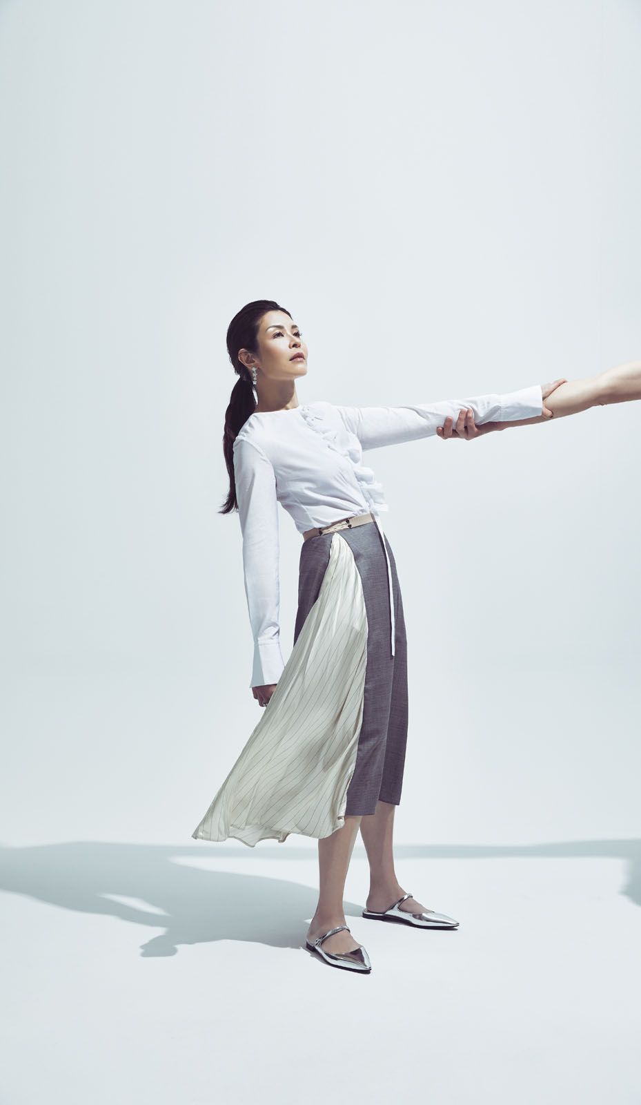 Winnie wears cotton shirt by 3.1 Phillip Lim; wool-blend skirt and Mary Jane flats, both by Prada; Folie des Prés earring and ring, both by Van Cleef & Arpels