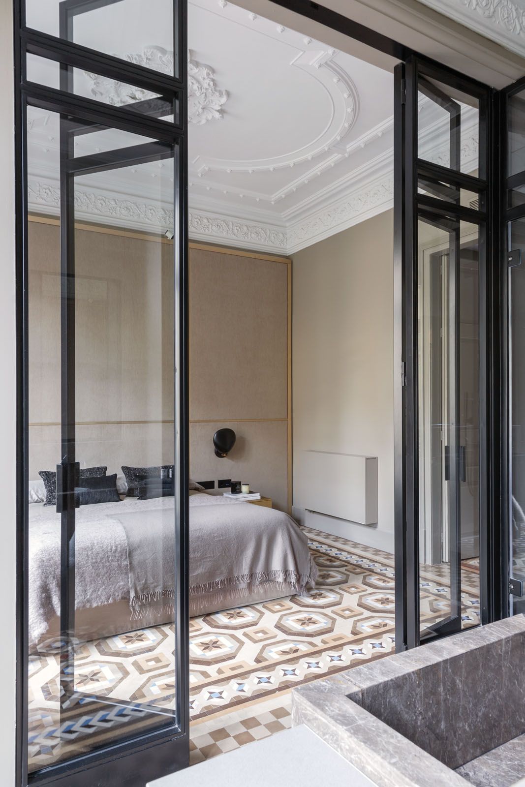 The full-length glass doors expand the sense of space in the master bedroom