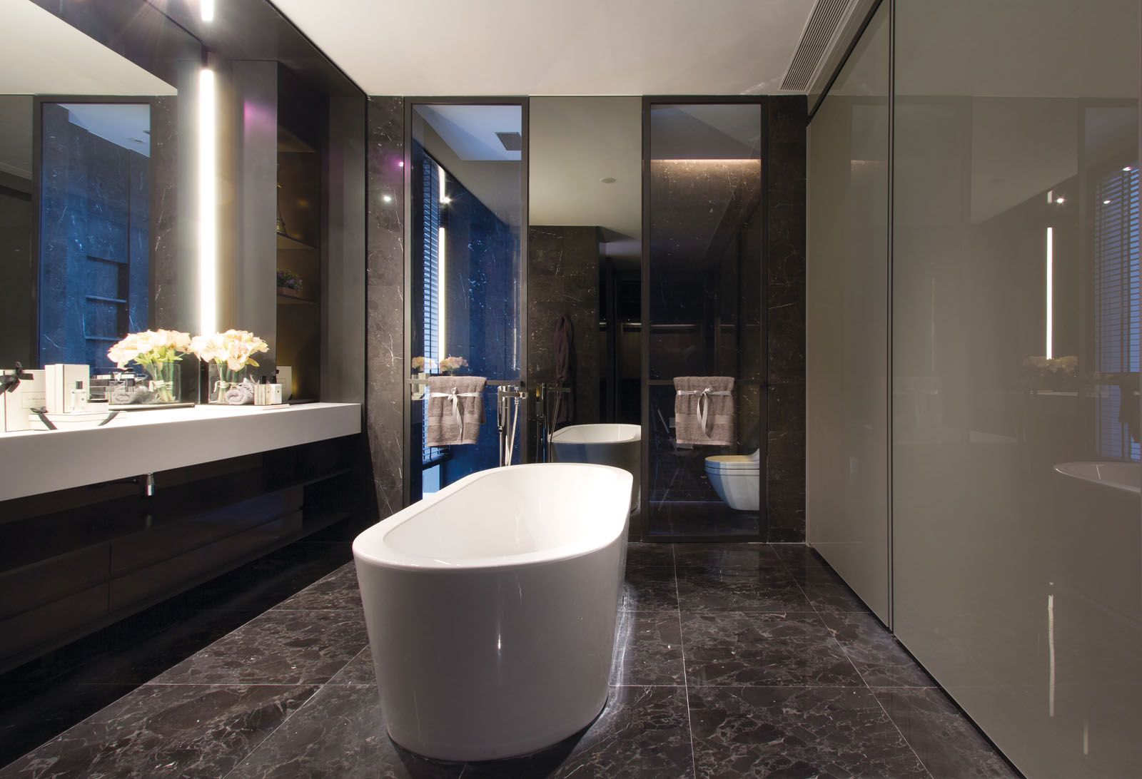 A free-standing bathtub serves as the focal point of the minimalist bathroom