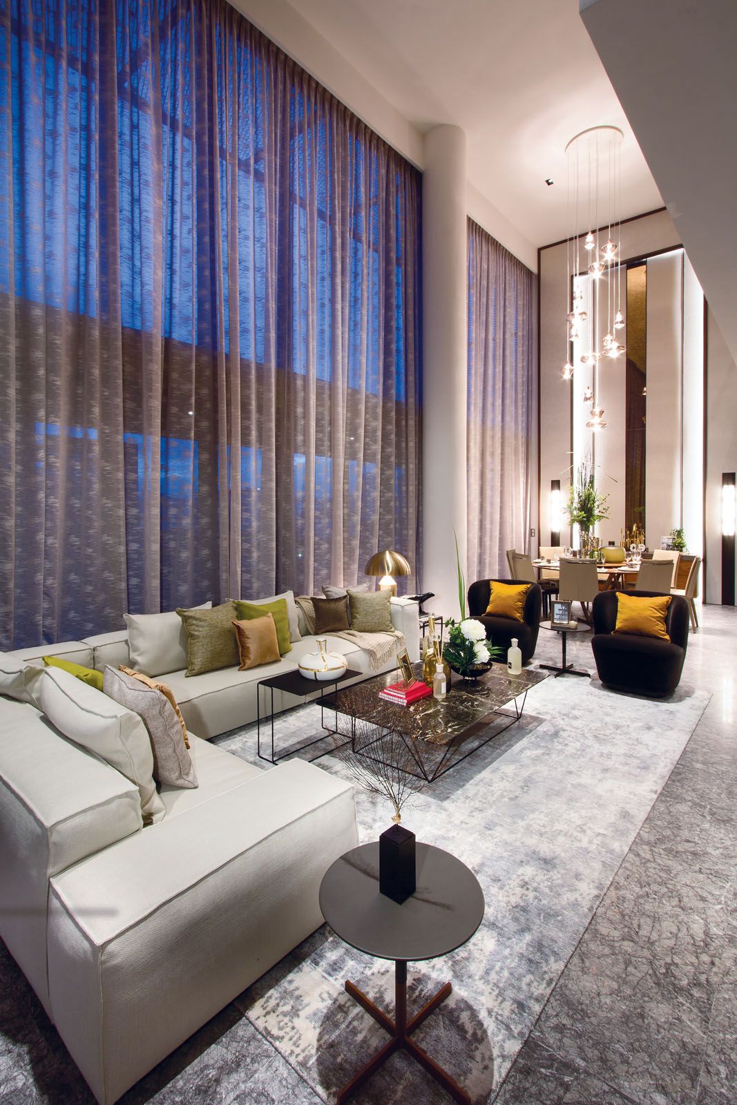 The Studio Italia Design chandelier that floats above the dining table draws attention to the voluminous height of the space