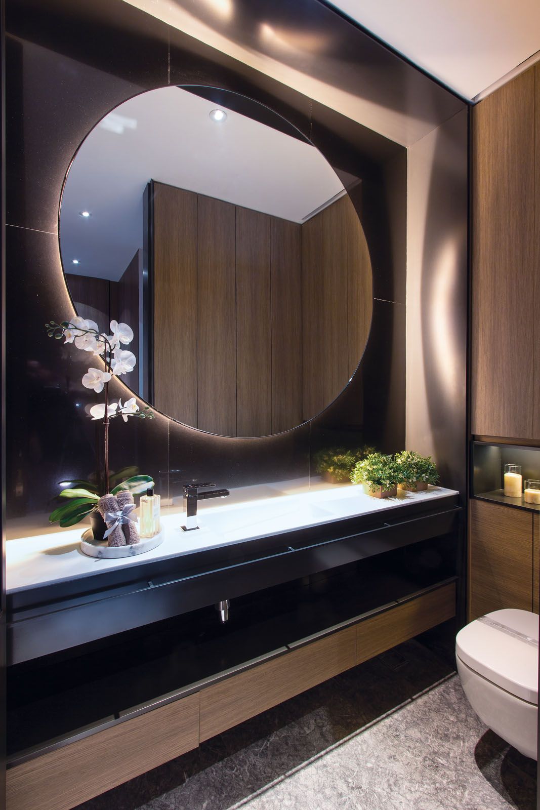 The back-lit mirror adds a touch of glamour to the powder room