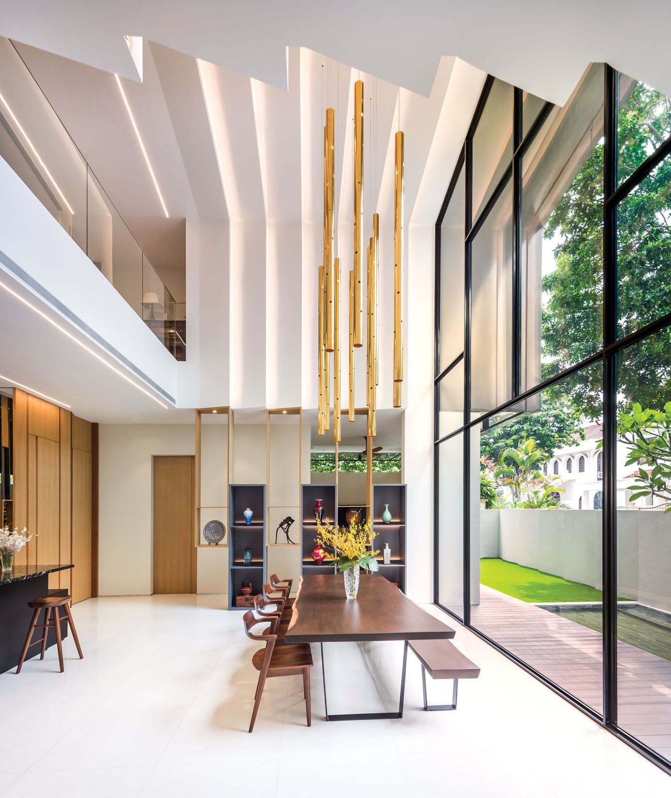 The sculptural pendant lights draw attention to the voluminous height of the dining area