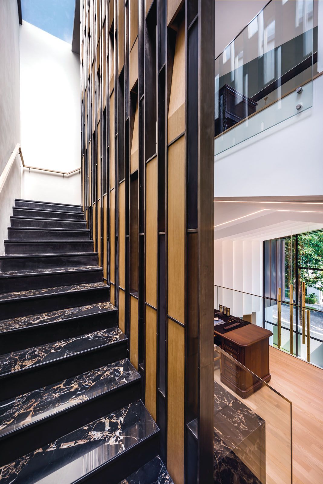 The metal screen that runs the full length of the staircase incorporates built-in lighting from the ground floor to the attic