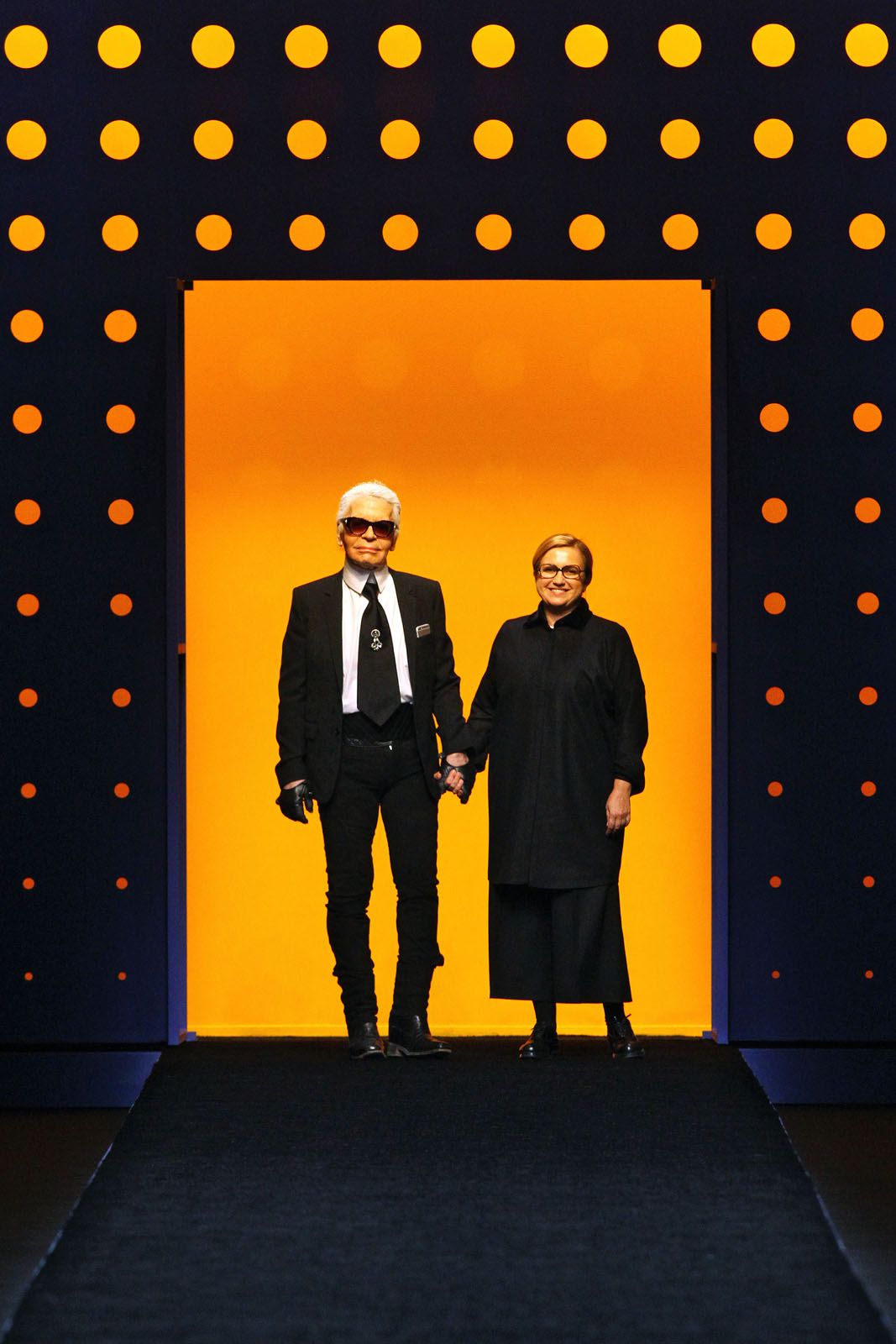 The designer taking the customary bow at a Fendi runway show in 2016 with accessories and menswear creative director Silvia Venturini Fendi