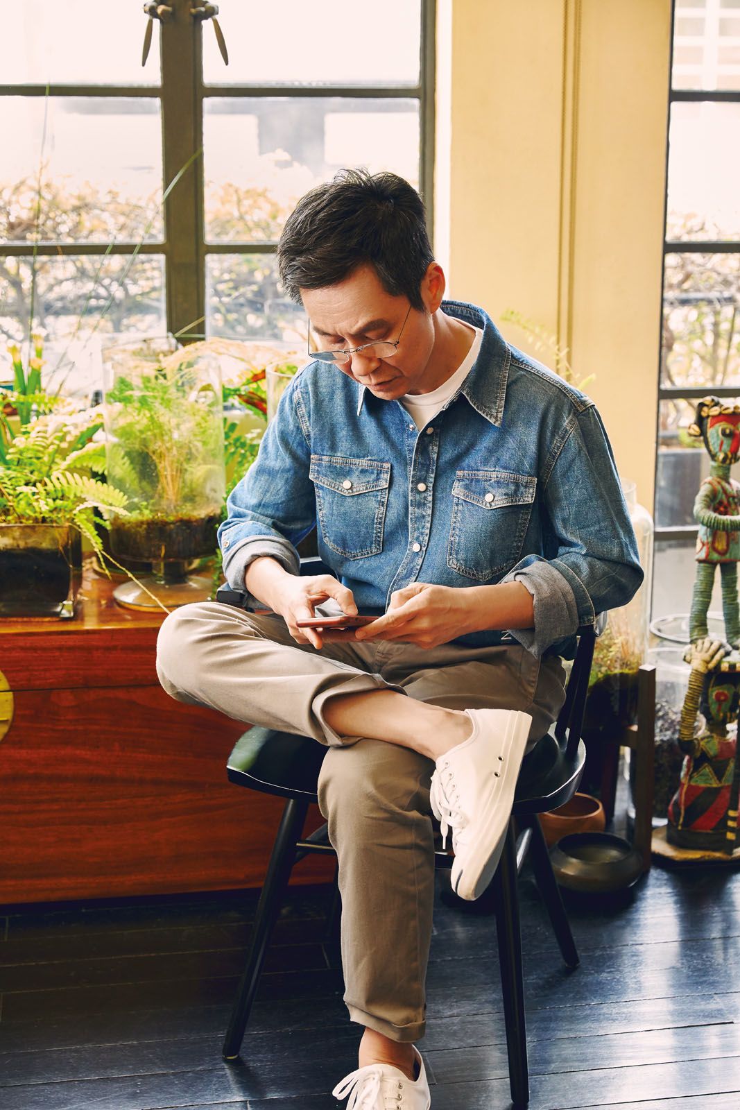 With work constantly on his mind, Wong Mun Summ is glued to his smartphone in between shots, and we managed to capture the moment. He wears denim shirt by Givenchy