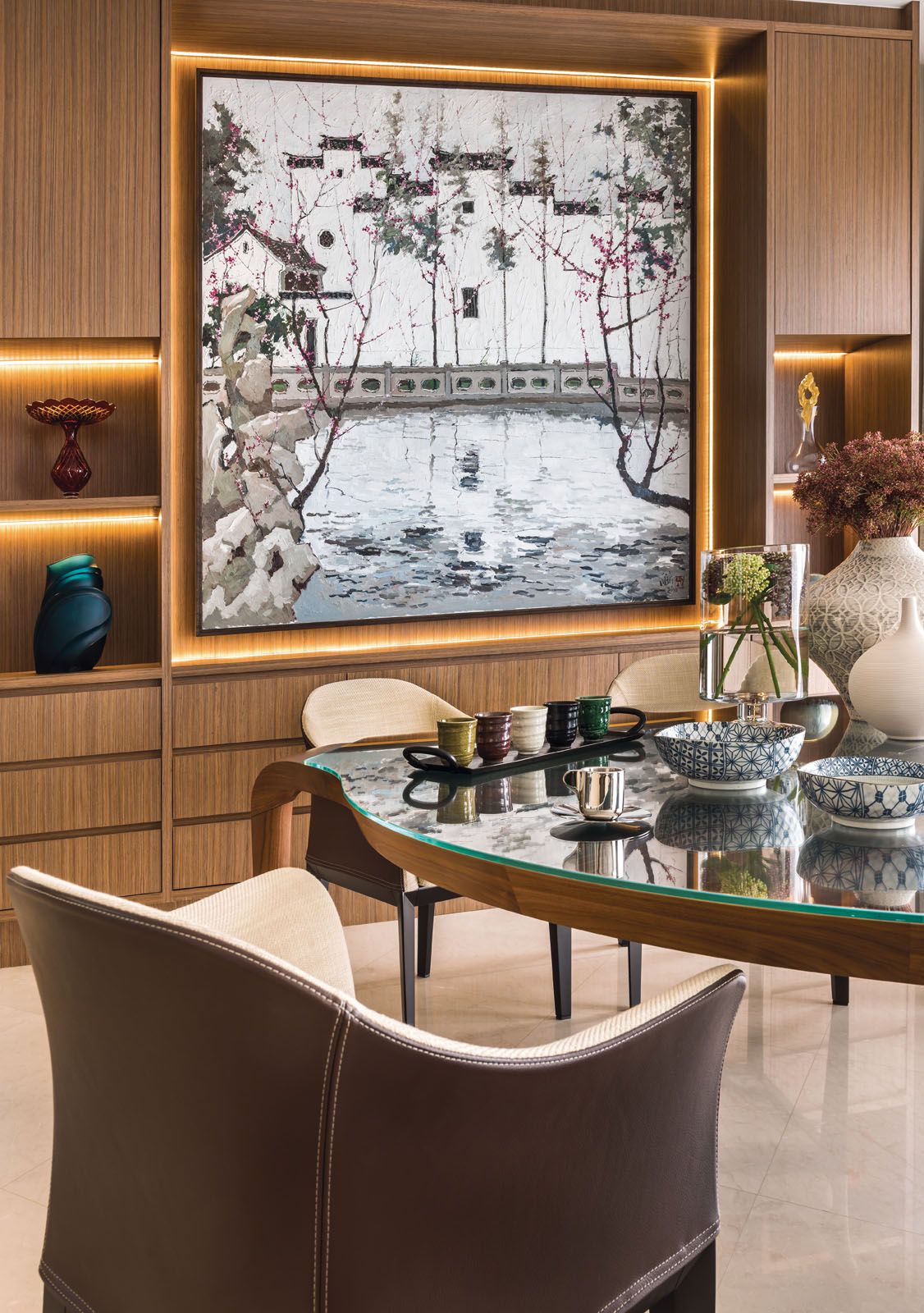 The built-in lighting draws attention to the painting and art objects at the dining area