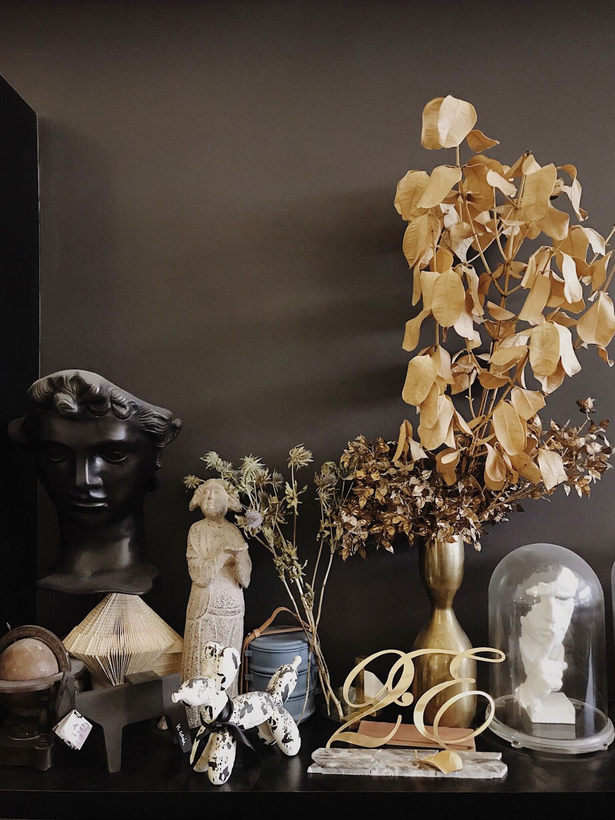 A creative selection of decor objects and dried plants adds visual interest to the show unit