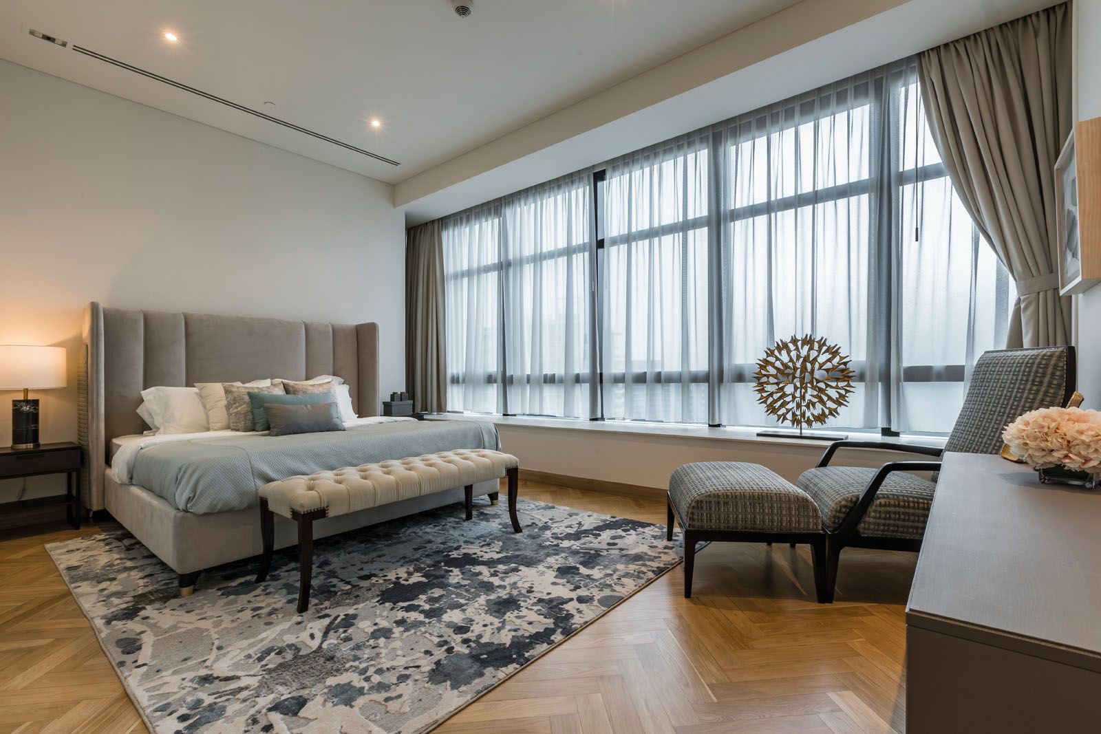The art-inspired rug grounds the look of the master bedroom