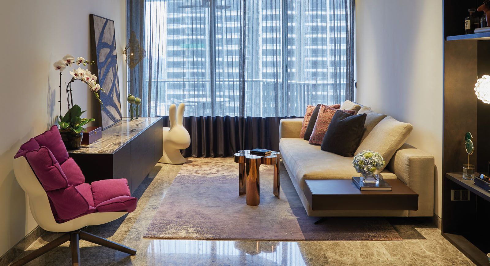 The magenta Husk armchair from B&B Italia adds a pop of colour to the living area