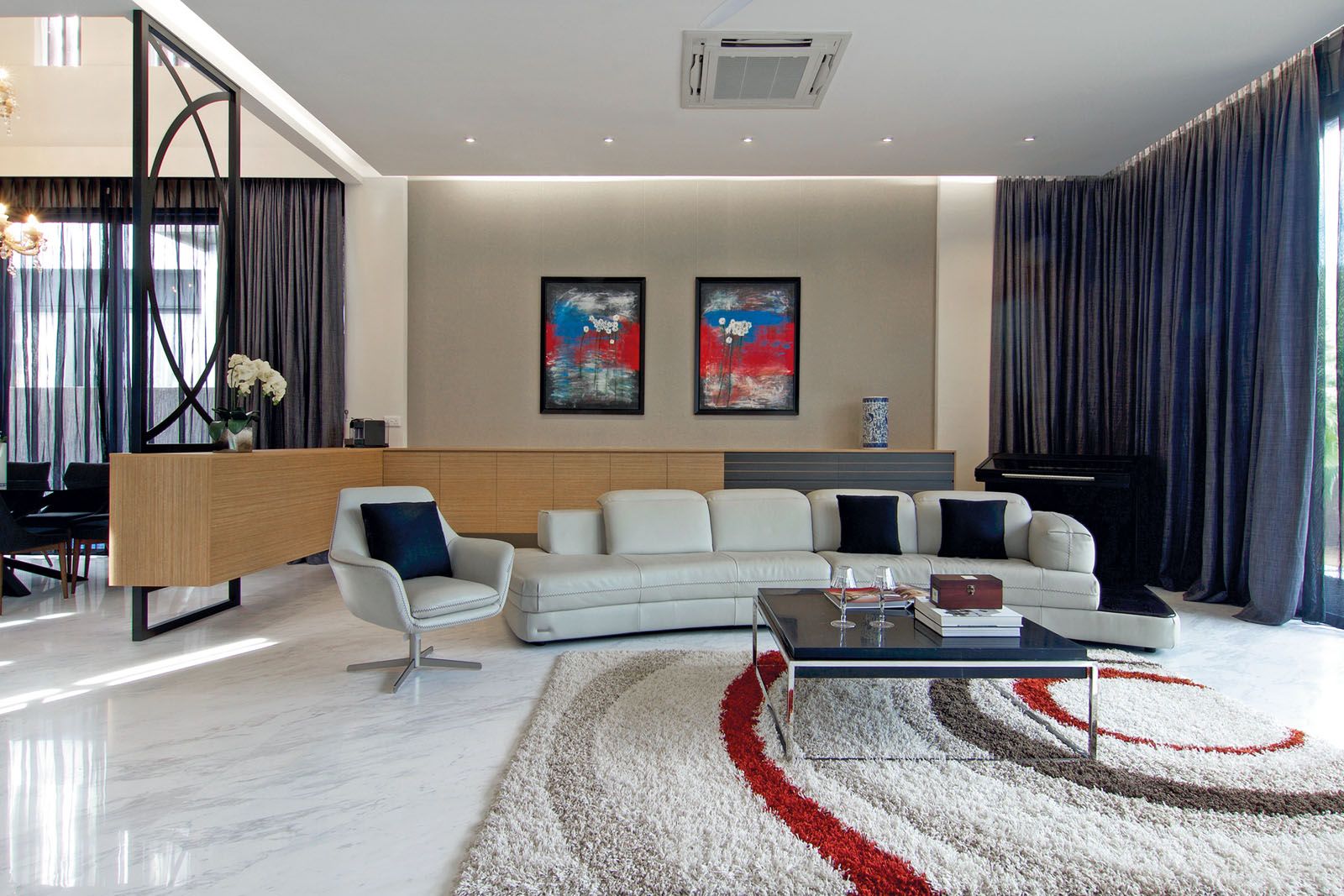 Splashes of colour on the paintings and a rug add personality to the light palette of the living room