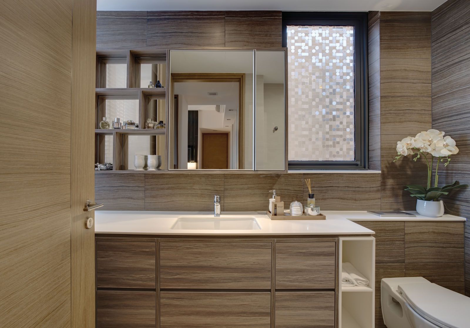 Wooden cabinetry and wall panels create a calming mood in the master bathroom