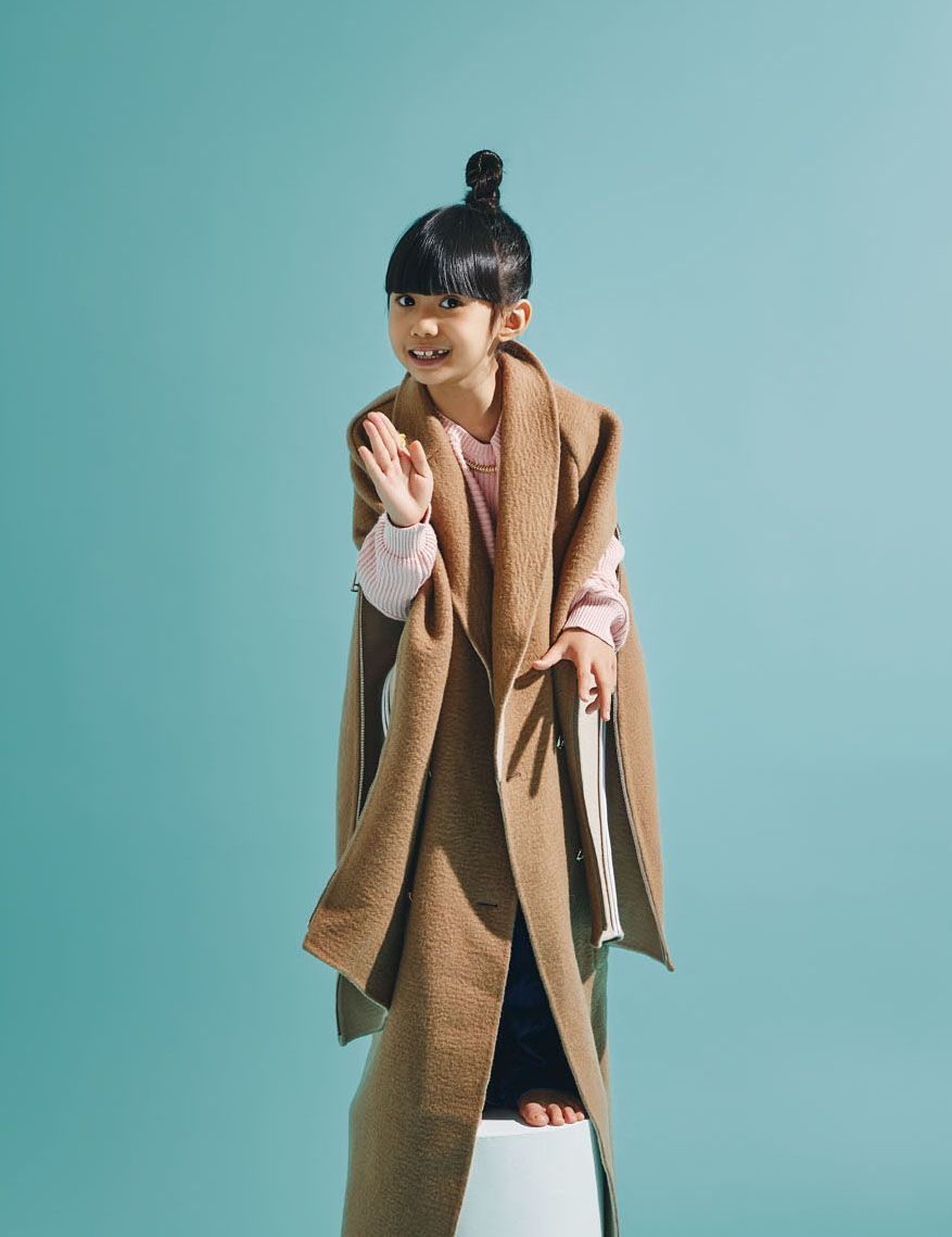 Kara wears knitted cotton sweater and denim flare jeans both by Stella McCartney Kids; wool coat with zip details by Fendi; Clash de Cartier necklace in pink gold by Cartier