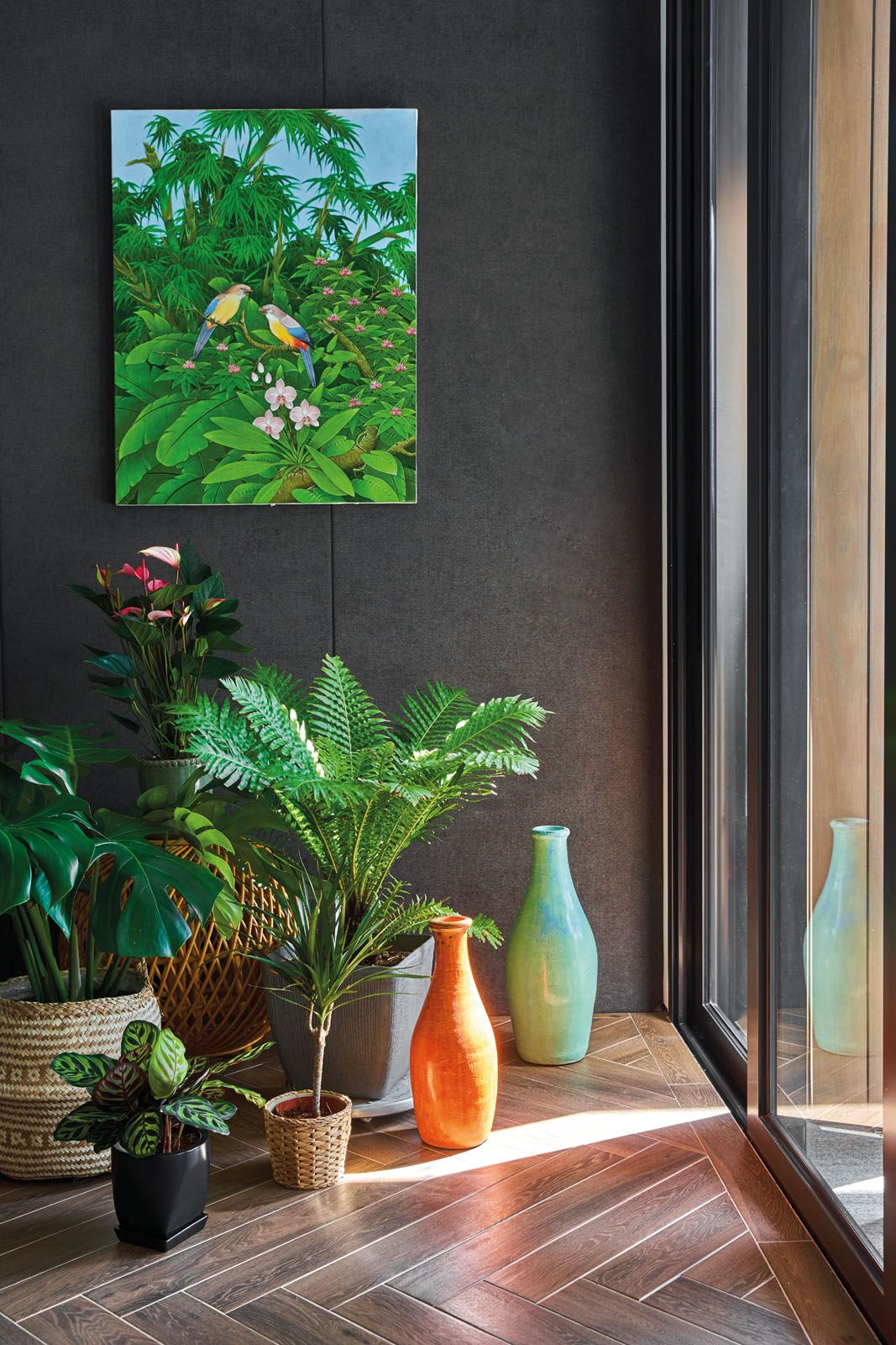 Potted plants liven up the home’s palette of dark grey and timber